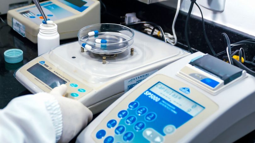 Equipe aplicando sanitização em sala de clínica com nebulizador e equipamentos de proteção